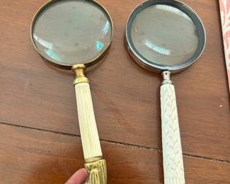 Pair of handheld magnifying glasses with decorative handles.