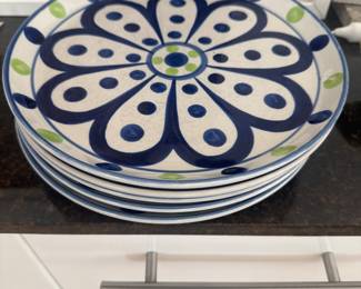 Stack of decorative blue-and-white plates with a bold floral pattern.