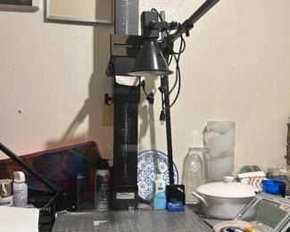 Floor-standing drill press with worktable and lever handles.