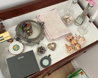 Assorted vanity items, small dishes, decorative objects, and accessories.