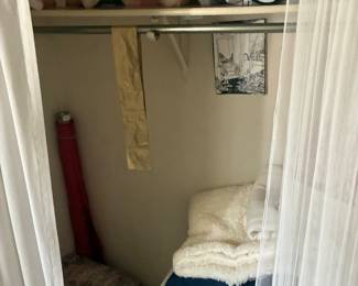 Closet assortment of hanging garments and folded linens.