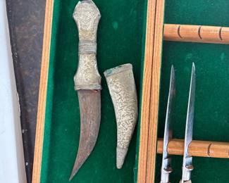 Decorative curved knives and sheaths displayed in a green-lined case.