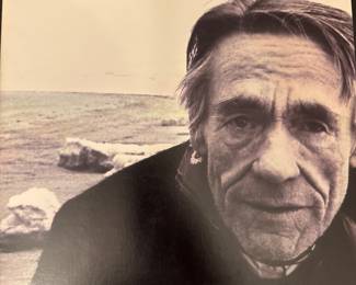Black-and-white photographic portrait of a man, shown outdoors.