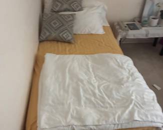 Bed with light-colored bedding and decorative pillows.