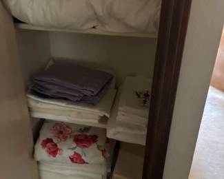 Assorted folded towels and linens in a storage cabinet.
