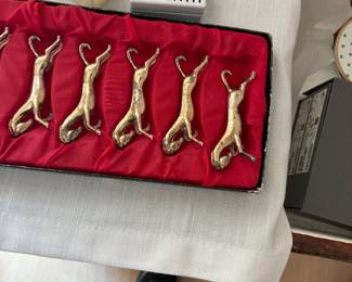 Six decorative animal-shaped knife rests displayed in a red-lined presentation case.