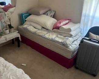 Bed with assorted pillows and folded bedding.