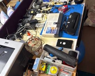 Assorted electronics, cables, and small accessories on a work surface.