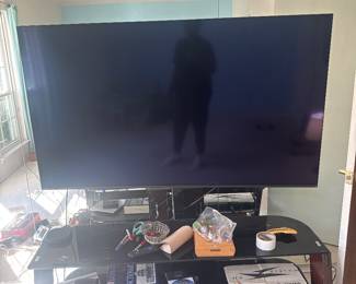 Flat-screen television displayed on a glass entertainment stand.