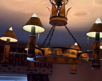 Vintage Federal / Colonial Revival Tole-Painted Six-Light Chandelier — Decorative circular metal chandelier featuring a mustard-yellow and black distressed finish, painted architectural landscapes and period-costume figures, six candle-style arms with matching conical shades, and chain suspension. An unusual statement fixture with traditional American decorative appeal.