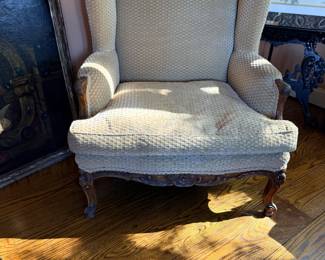 French Louis XV–Style Carved Wood Wingback Armchair — Elegant upholstered armchair featuring a high winged back, gently rolled arms, carved wooden frame with floral detailing, and graceful cabriole legs. Upholstered in a neutral cream-and-beige geometric woven fabric. A classic French Provincial accent chair suitable for a living room, bedroom, or reading nook.