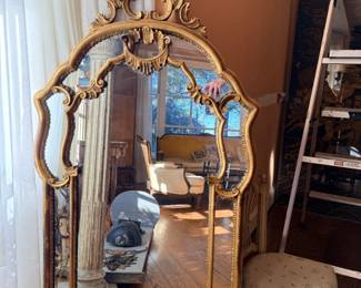Large ornate giltwood-style mirror in the French Louis XV / Rococo Revival taste, featuring an elaborate pierced foliate crest, scrolling acanthus decoration, shaped frame, and decorative inner molding. Gilt finish with age-related patina. An impressive architectural accent suitable for an entryway, mantel, or formal living room.