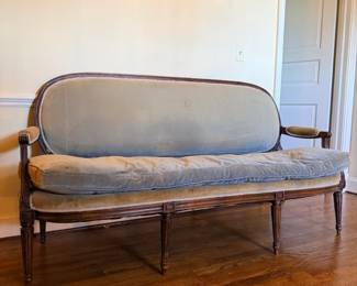 French Louis XVI–style upholstered settee or canapé, featuring a carved wooden frame, fluted legs, and pale blue-gray velvet upholstery