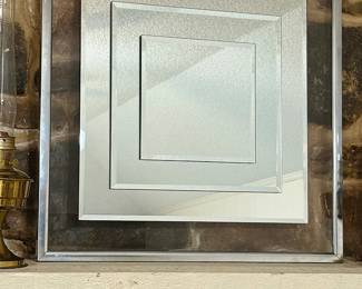 Modernist float-mounted beveled mirror.