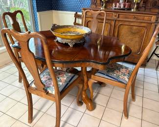 Antique English walnut dining table with turtle-back top, and vintage Queen Anne style oak side chairs.