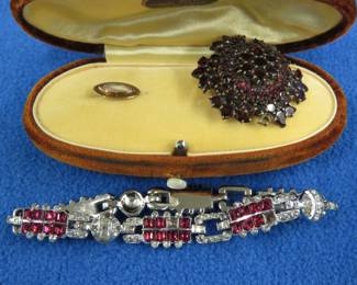 Lot 171. Described by prior owner as a garnet pin with 3 missing stones, bracelet and a vintage jewelry box