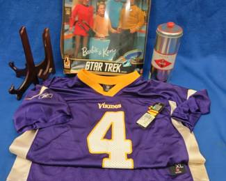 Lot 379. NOS Brett Favre jersey size on tag is XL (but looks smaller), Star Wars Barbie and Ken dolls and a vintage Coca-Cola. straw dispenser