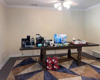 Solid wood expandable dining table sits 10. Blue and brown area rug. Small kitchen appliances.