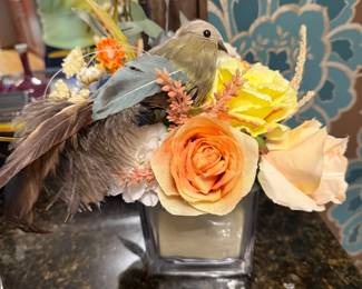 Silk floral arrangement with a bird in a glass vase