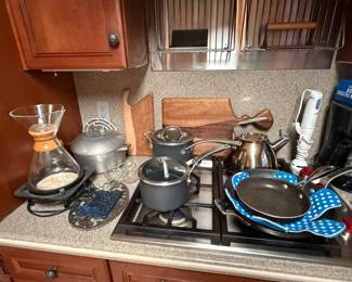 Gas cooktop with kettle, pans and counter appliances