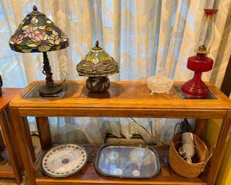 Stained glass table lamp and ruby glass oil lamp on a shelf