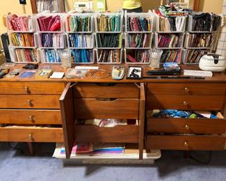 Sewing cabinet with wall racks of folded quilting cotton above