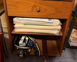 Cabinet with folded batting, fabric and a sewing machine below