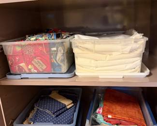 Bins of fabric and folded batting on a shelf