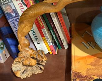 Carved wood figure with books and a globe