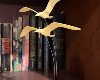 Brass seagull sculpture on a bookshelf