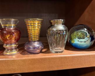Art glass vases and a paperweight on a shelf