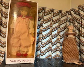 Boxed porcelain doll and a cloth doll on a stand