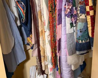 Closet of hanging quilts and fabric lengths