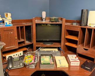 Corner computer desk with monitor and office supplies