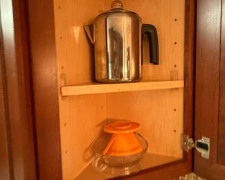 Cabinet with a stovetop percolator and ceramic bowl