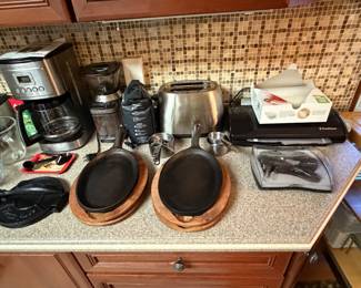 Kitchen counter with coffee maker, skillets and small appliances