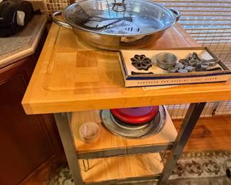 Butcher block cart with a metal bowl and trivets