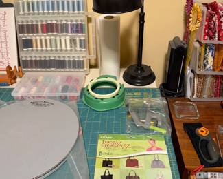 Sewing table with magnifier lamp, thread storage and cutting mat