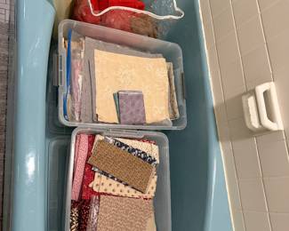 Bins of folded fabric stored in a bathtub