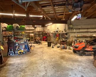 Garage with workbench, shelving and yard equipment