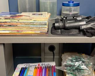 Shelf with binoculars, markers and reference books