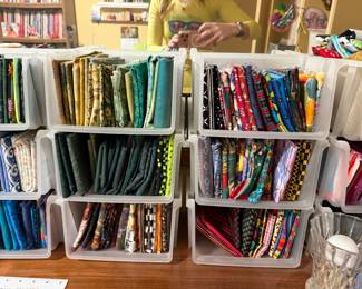 Open bins of folded fabric sorted by color