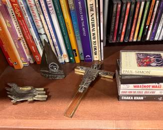 Brass crucifix and cassette tapes on a bookshelf