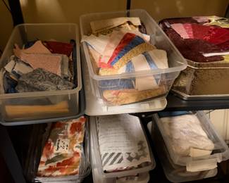Bins of fabric scraps, batting and quilt blocks