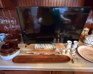 Kitchen counter with flat screen television and serving pieces