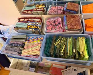Bins of folded quilting cotton sorted by color family