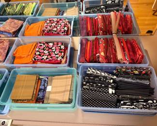 Bins of fabric in reds, oranges and black and white prints