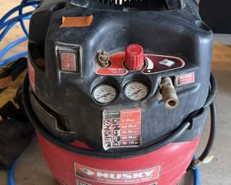 Husky 1.5 HP 6-gallon pancake air compressor with attached blue hose