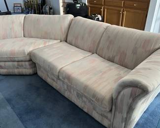 Vintage 1980s-1990s two-piece curved sectional sofa with pastel flame-stitch style fabric upholstery.