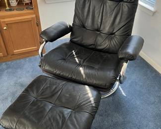 Black leather tufted swivel recliner and matching ottoman with tubular chrome bases, late 20th century.
